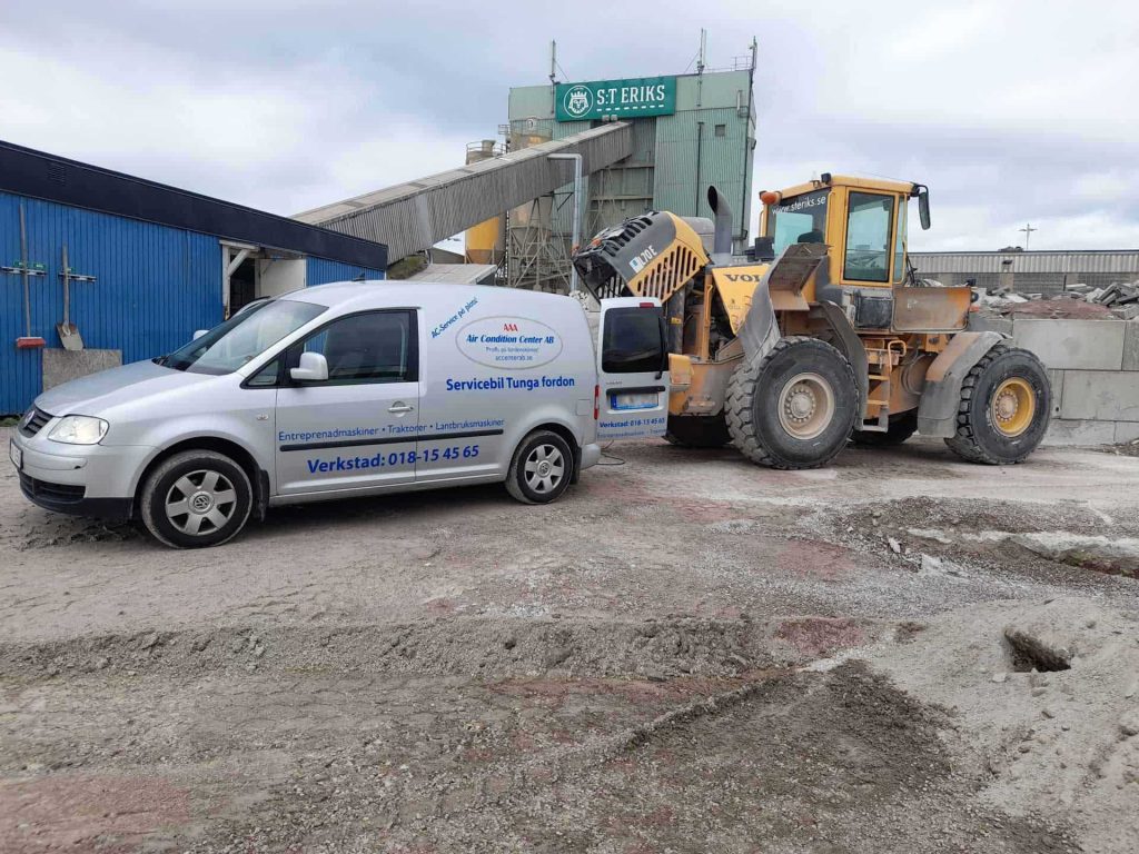 En servicebil kommer för att reparera AC:n i en Entreprenad.